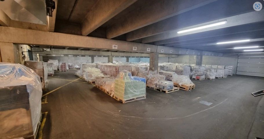 Lager med store mængder emballagemateriale på paller og forseglet med plast. Det er lige mange krydslagte strøgbånd på