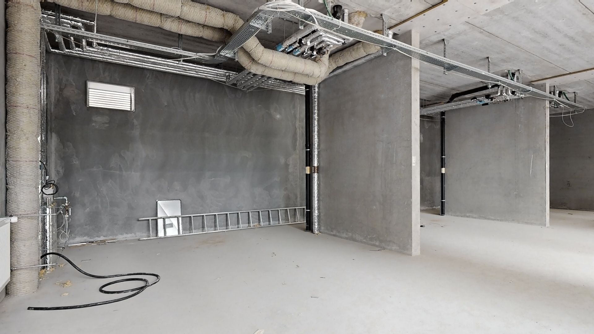 Rørlig lagerrum i en underjordisk bygning med jord og betonvægge, en stige og et slangesystem til klimaanlæg