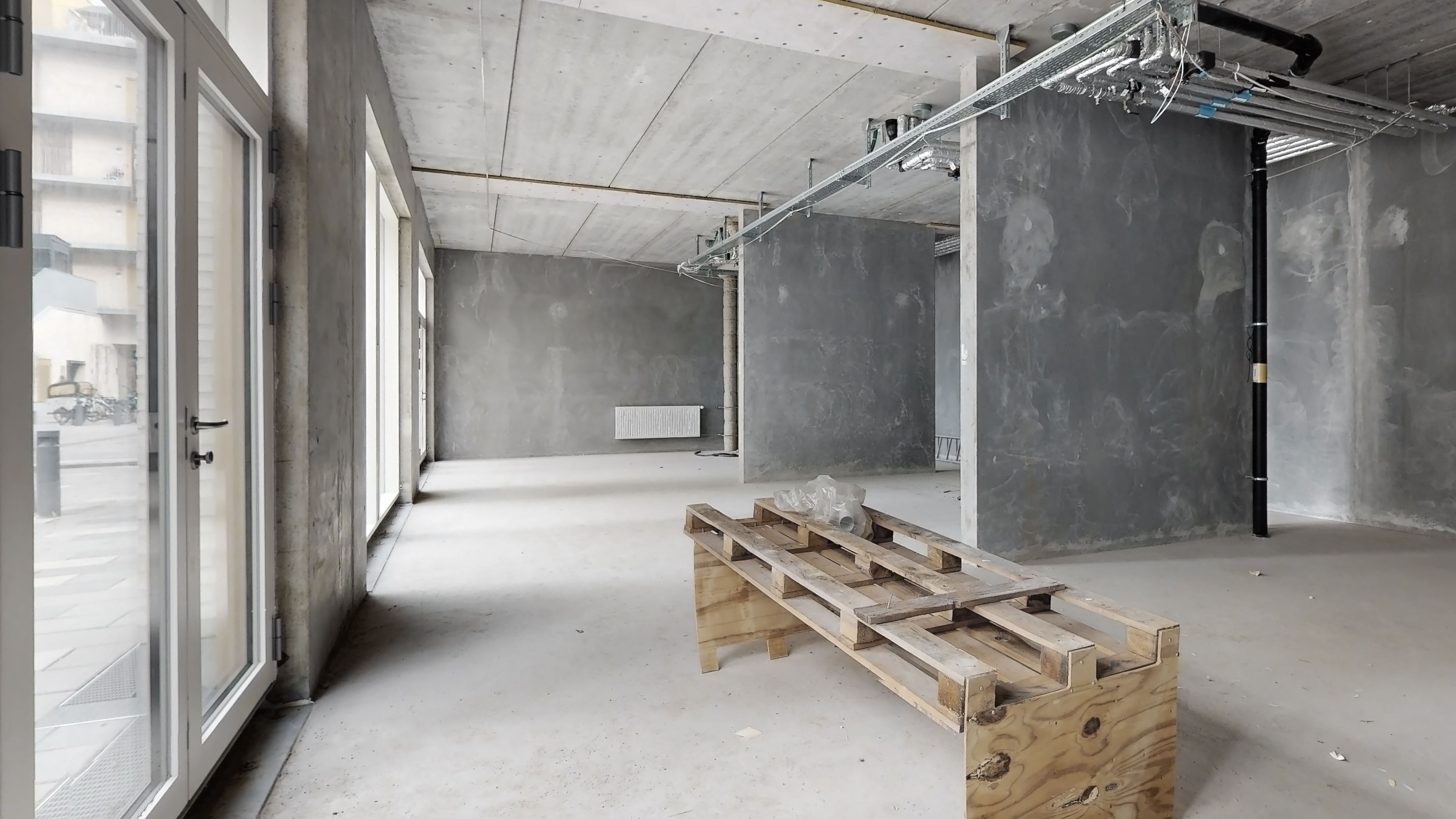 En ny bolig i Rødovre med hvide vægge og gulv samt træbænk og plastikposer