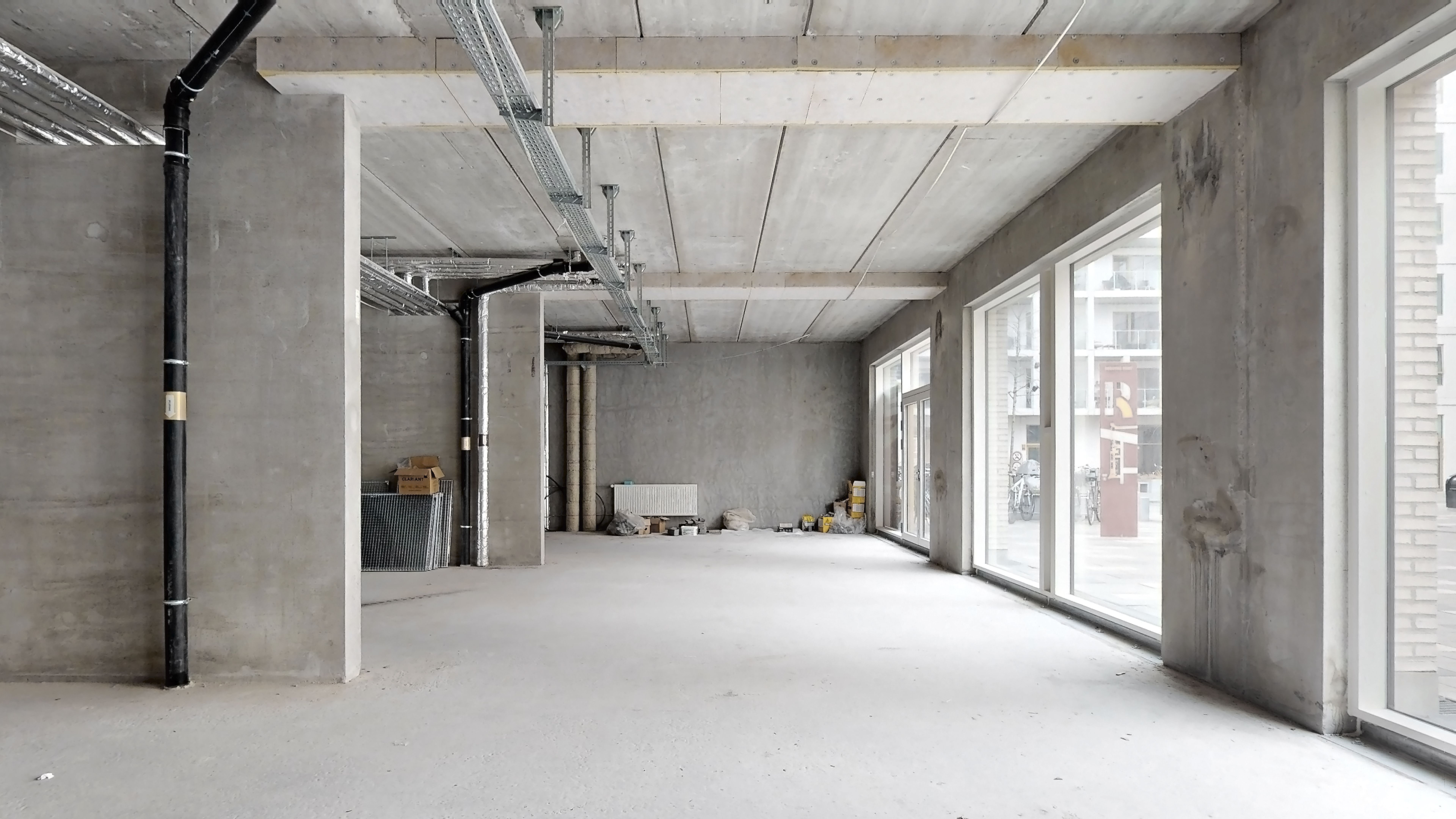 En ny bygning i Rødovre med en stor, tom rum med store vinduer og en hvid gulv