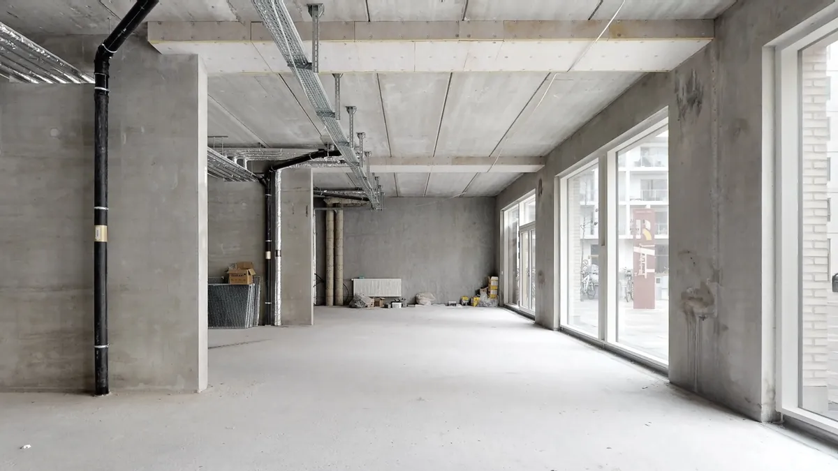 En ny bygning i Rødovre med en stor, tom rum med store vinduer og en hvid gulv