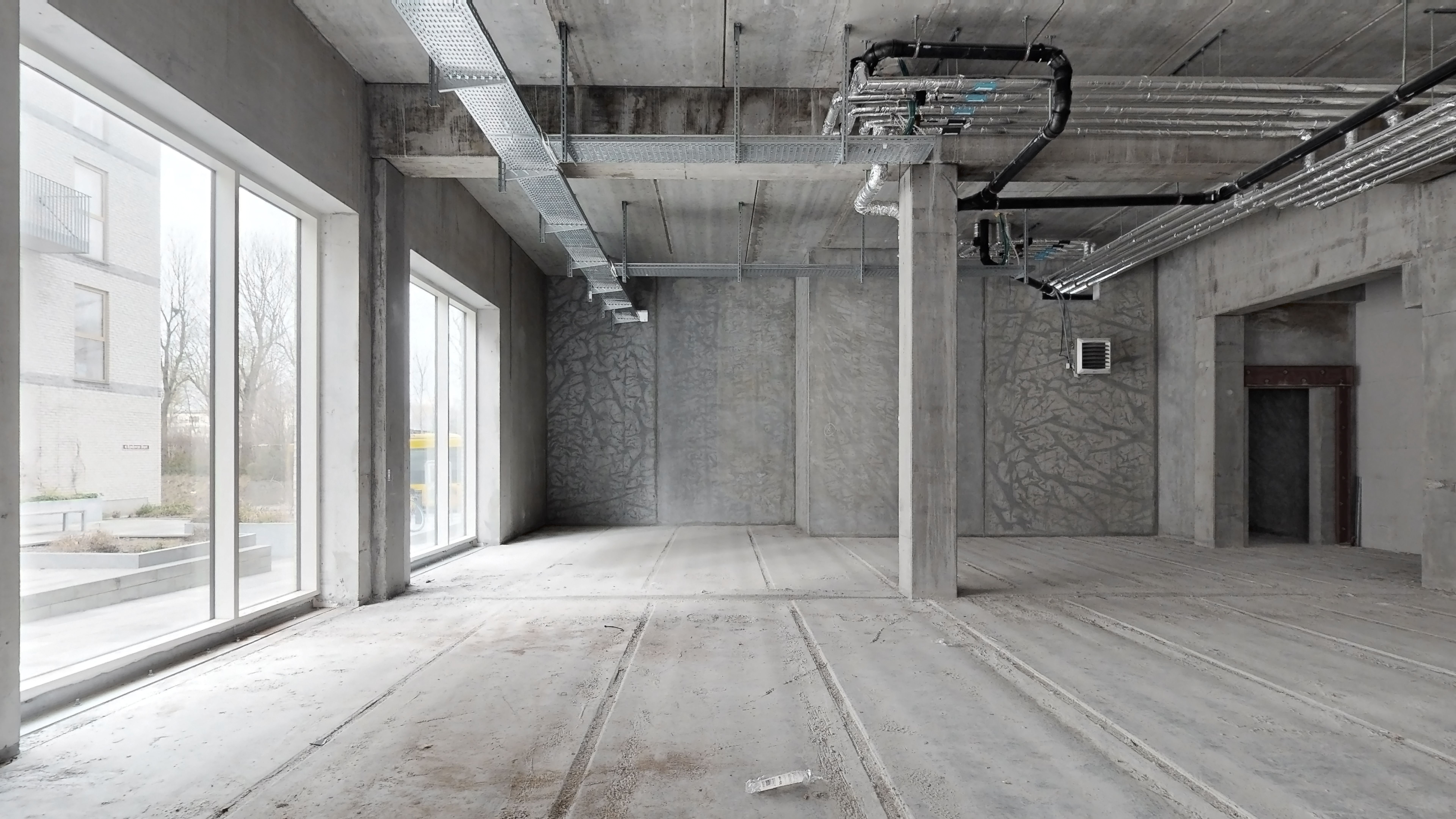 Store, tomme lokaler med vinduer og store gulvflader, lyse og rummelige. Der er røde spor på gulvet.