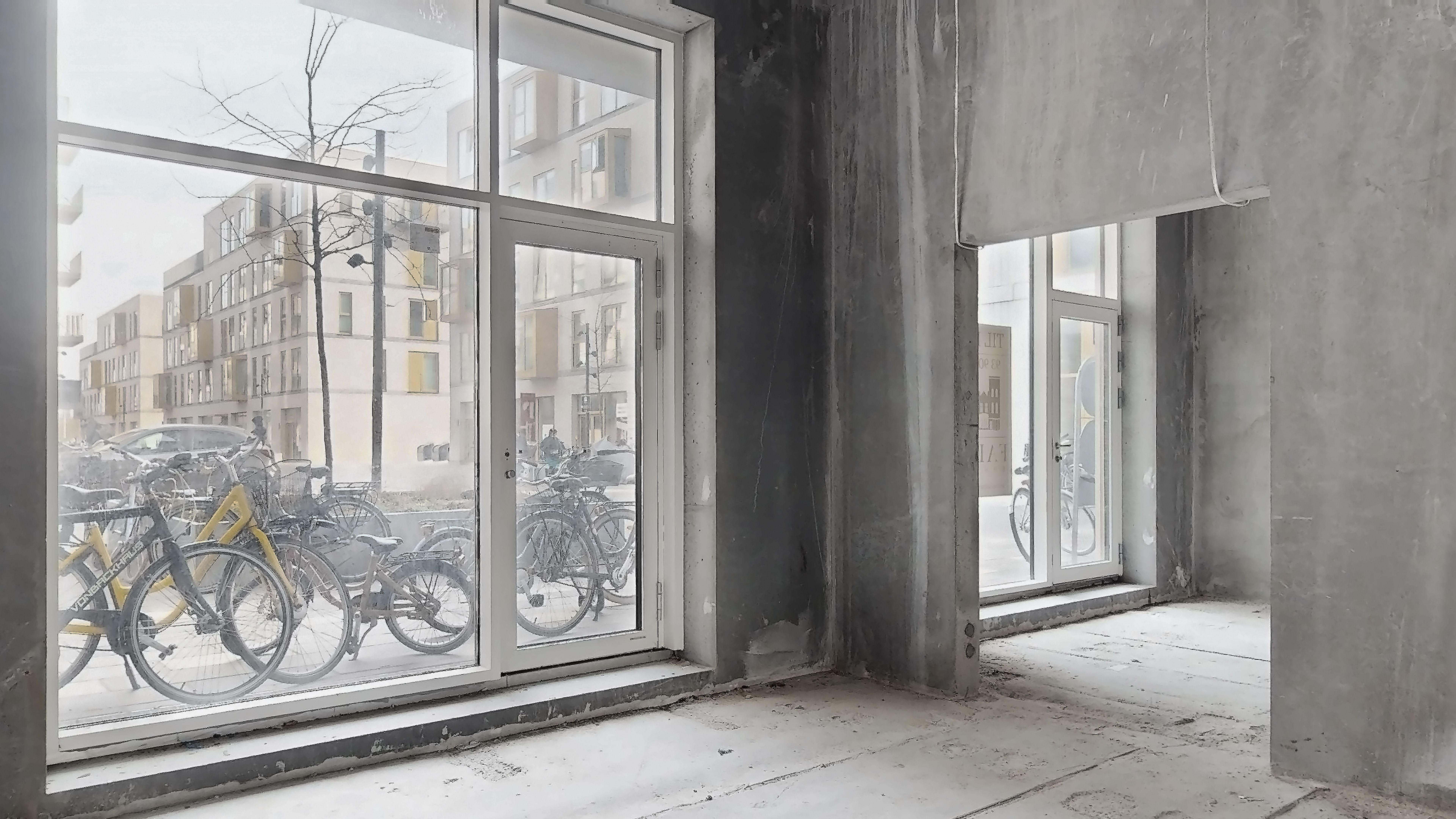 En renoveret stueetage med nye vinduer og døre, og flere cykler parkeret udenfor i området