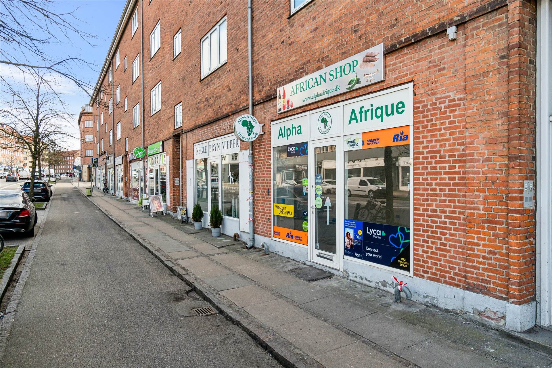 Butiksforretninger med forretningsnavne som African Shop, Alpha, Afrique og Ria Money Transfer ligger ved siden af hinanden