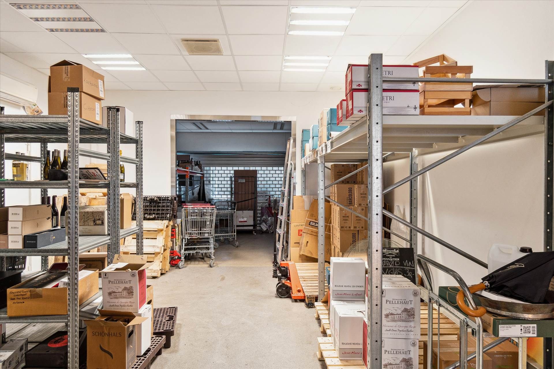 Lager med flere regnbuefarvede bokse og et stående sættelyd med en paraply i lokalets midte