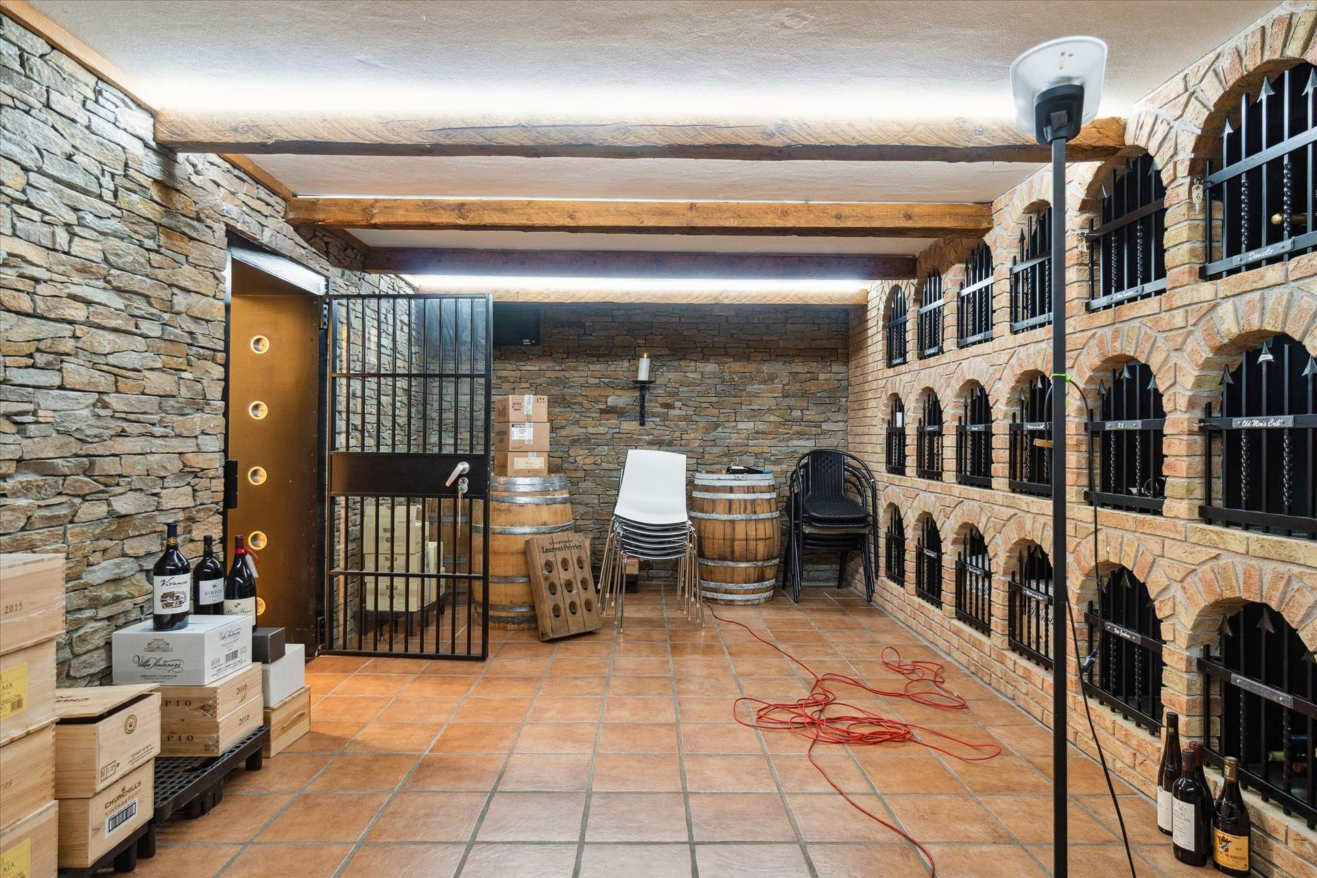 Et vinlager med en række vinkældre og en lille høj til vinflasker og stolpe til at stå på.