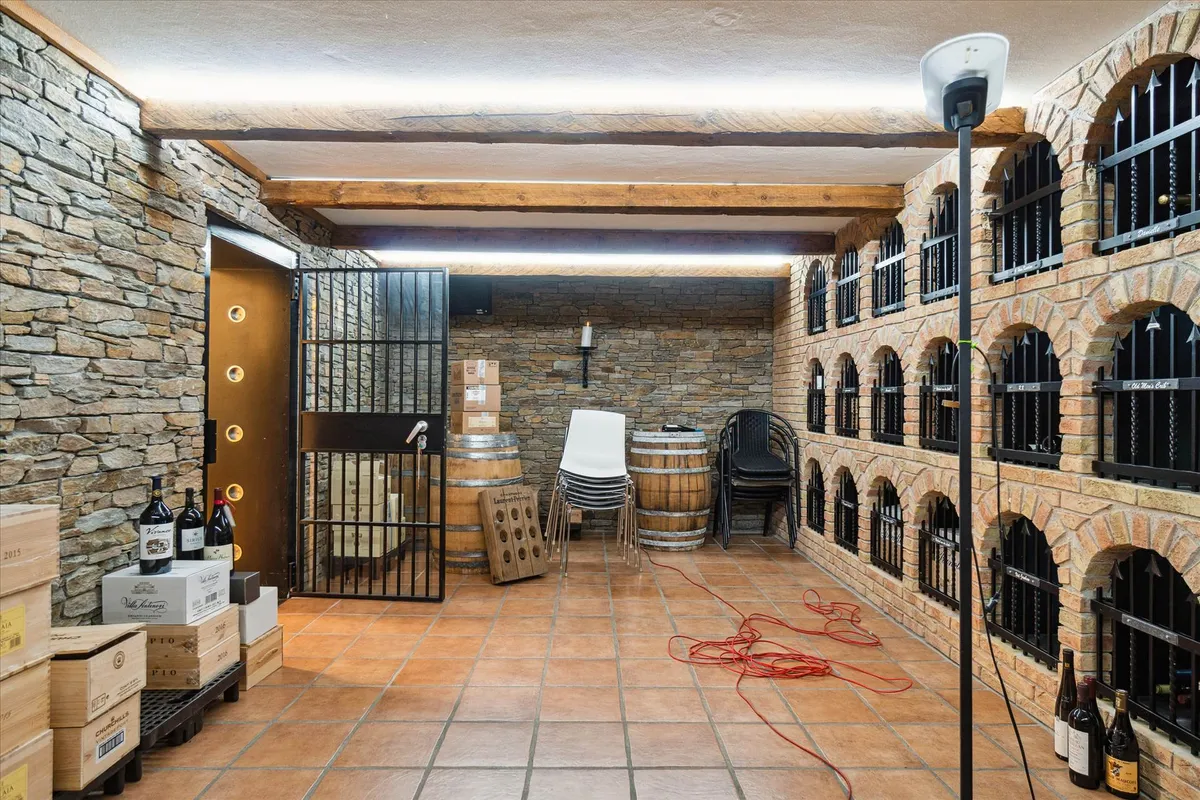 Et vinlager med en række vinkældre og en lille høj til vinflasker og stolpe til at stå på.