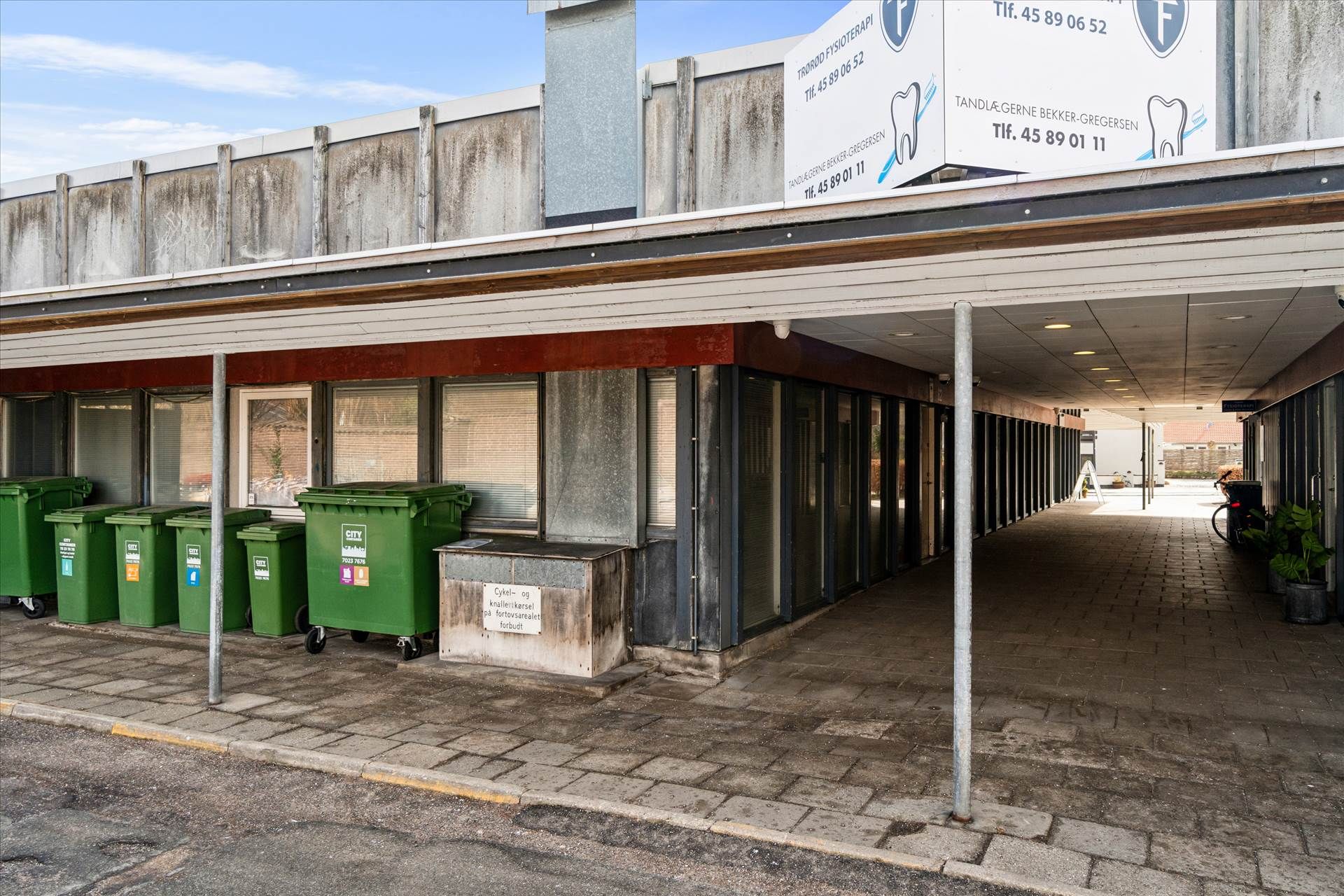 Lej lokale med gårdhave i centrum af Køge, med moderne design og grønne affaldscontainere foran bygningen