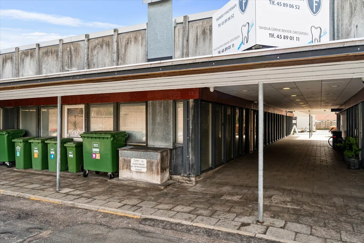 Lej lokale med gårdhave i centrum af Køge, med moderne design og grønne affaldscontainere foran bygningen