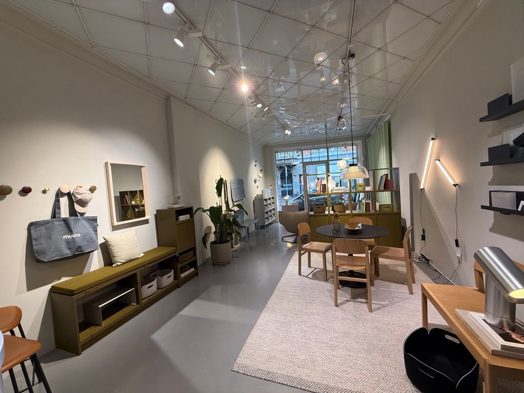 En moderne indretning med møbler, stolpe og højt loft med indbygget belysning samt smykkehylder og plante