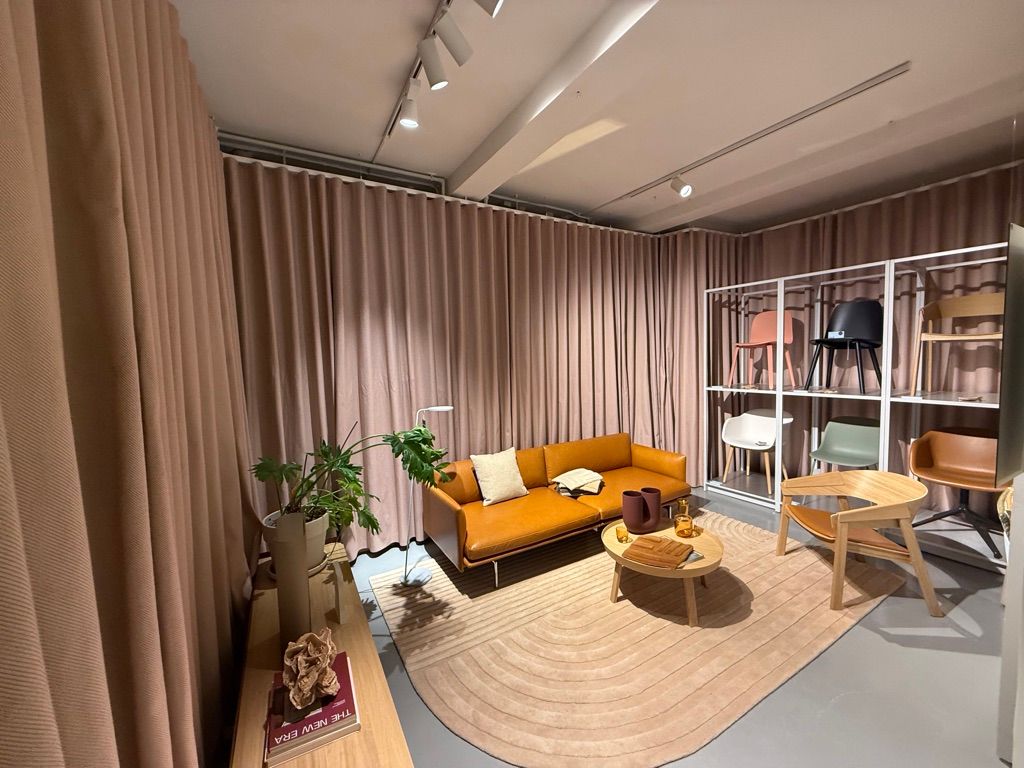 En luksuriøs lounge med en beige sofa, en træbord med krydderi og træstole samt en plante i en hvid potte