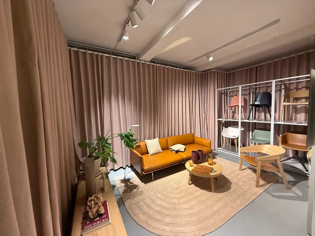 En luksuriøs lounge med en beige sofa, en træbord med krydderi og træstole samt en plante i en hvid potte