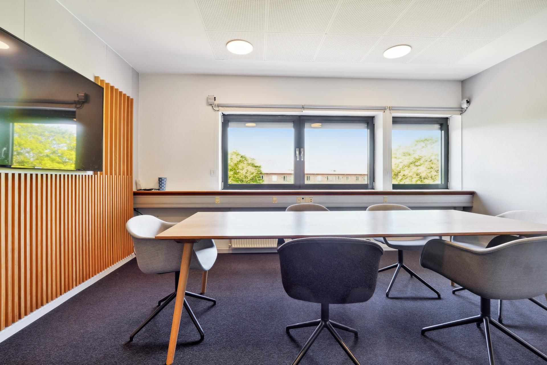 Kontor med møbel og tekstiler i lyse farver og lysevinduer i en forretningsbygning