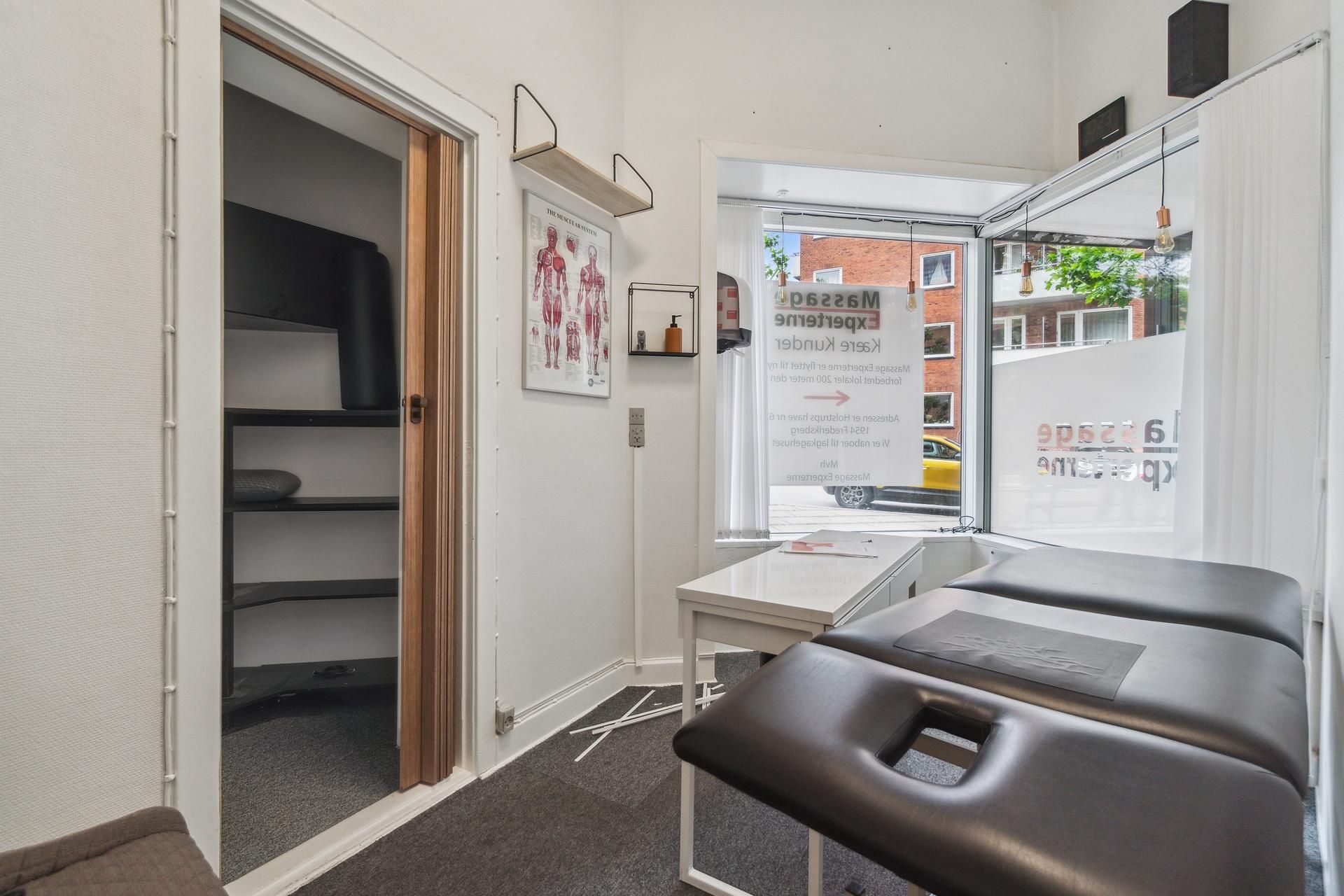 Rum i lejemål med kinesiologiske behandlingsborde og indretning til massage og fysioterapi med adgang til gaden og udsigt