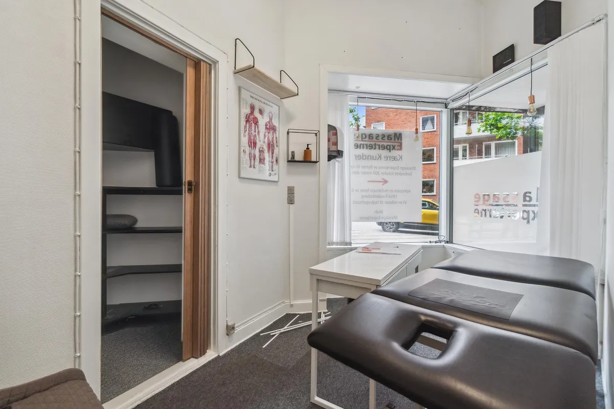 Rum i lejemål med kinesiologiske behandlingsborde og indretning til massage og fysioterapi med adgang til gaden og udsigt