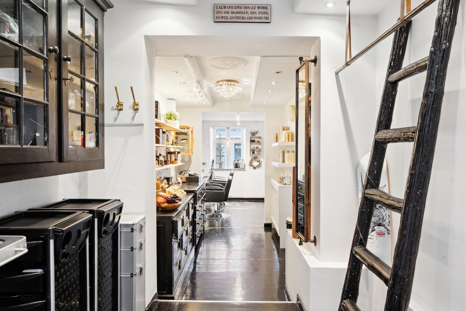 I en moderne stue er der en luksuriøs højre sektion med et hvidt loft, lysekroner, og en skraveret stol. Der er en sort og