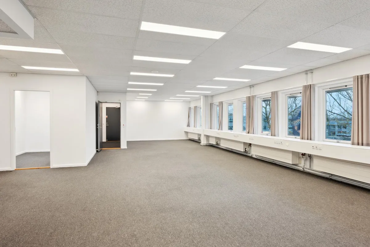 Store møde- og konferencelokaler med lyse gulve og vægge, højt til loftet, store vinduer og mørke gardiner