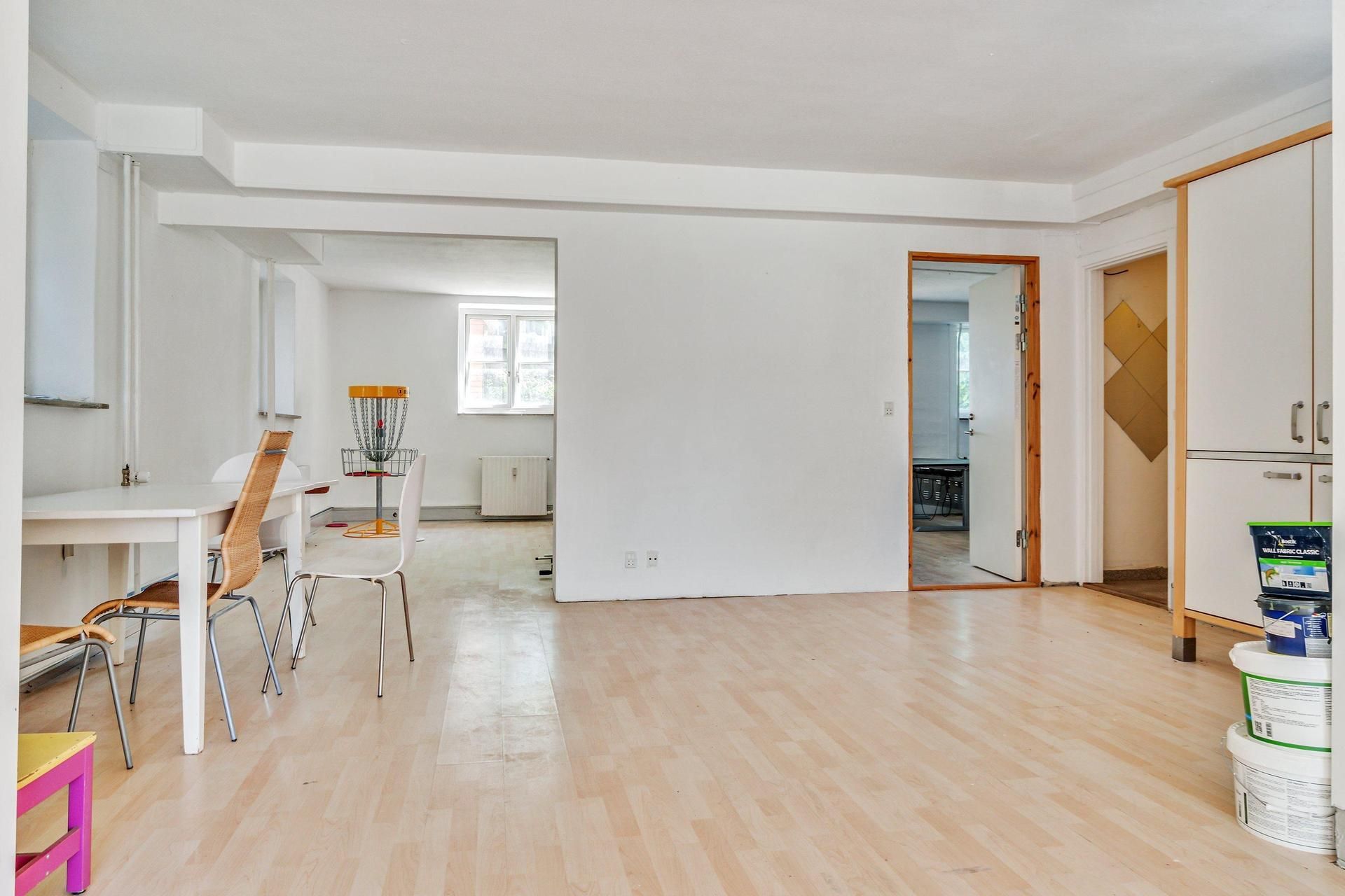 Regelmæssigt kontorlokal med hvide vægge og trægulve samt diskgolfbane i kontoret