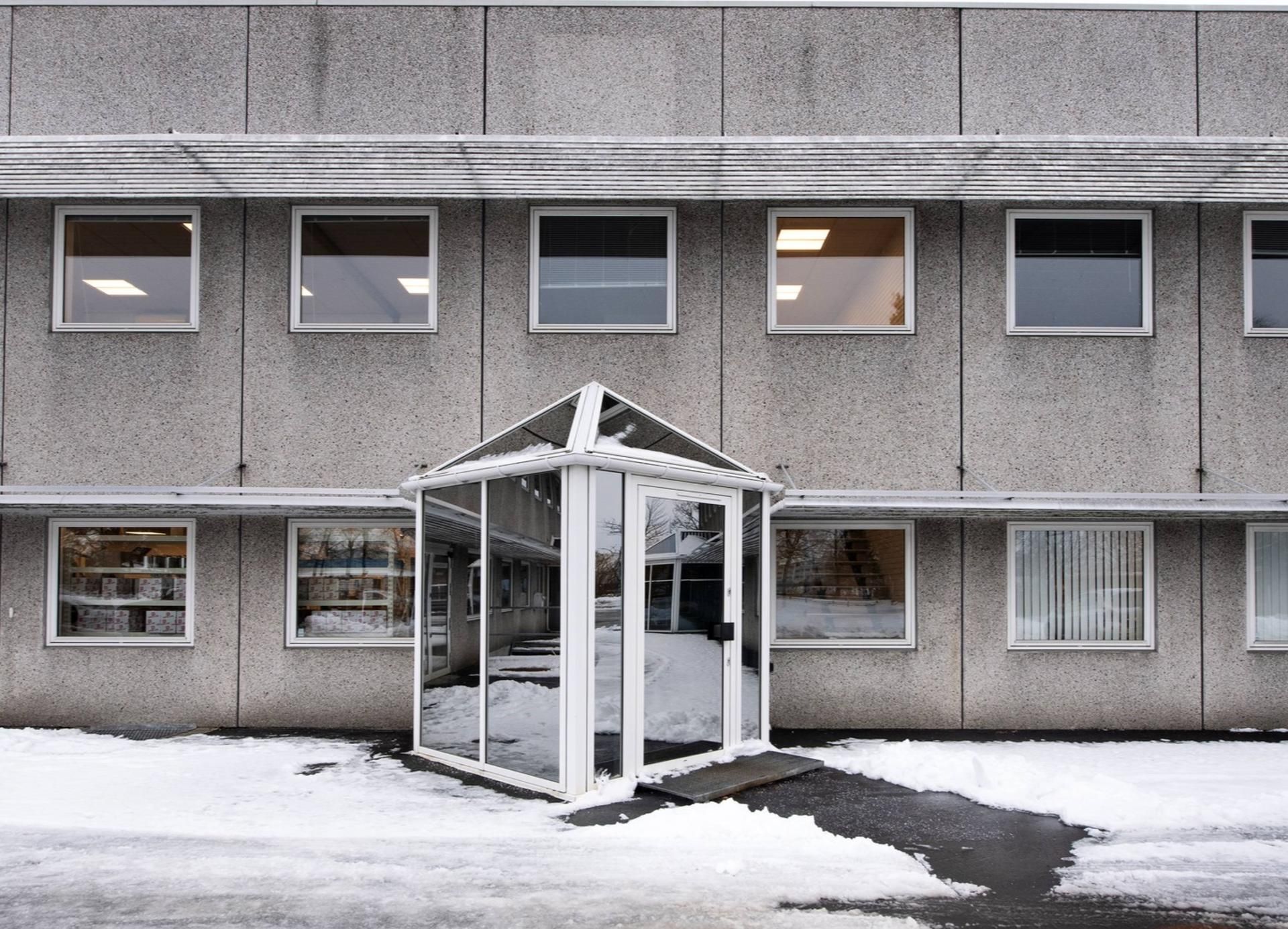 En bygning med højt gips og højt vinduesudvalg og en dør til kontorlokaler med en glasdækning