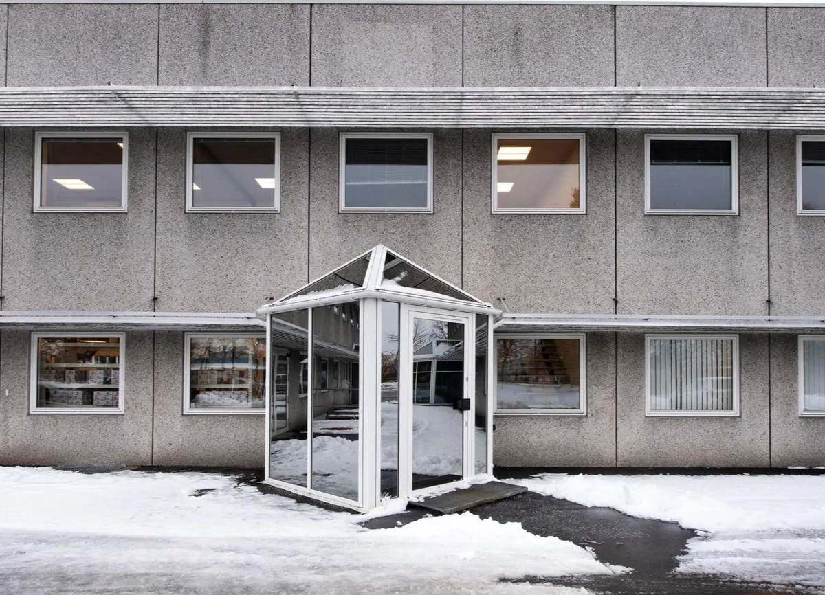 En bygning med højt gips og højt vinduesudvalg og en dør til kontorlokaler med en glasdækning