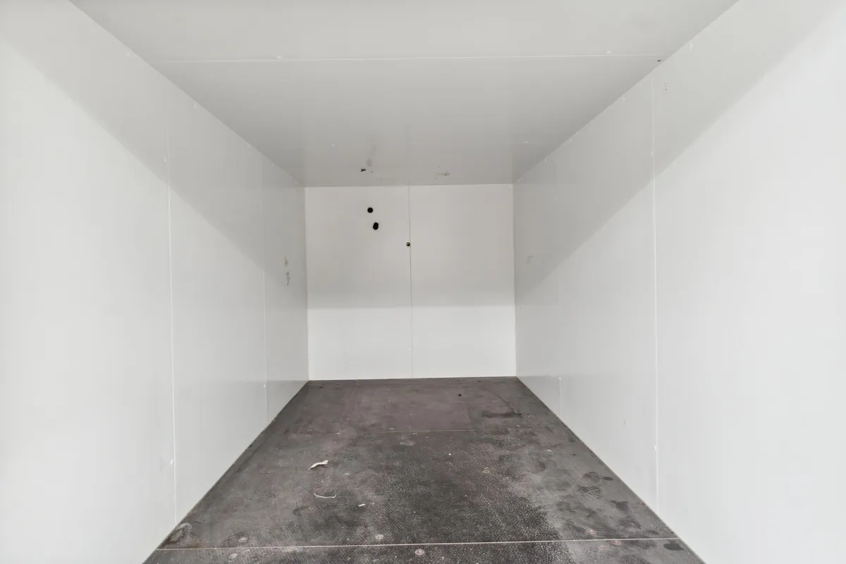 Lager med hvide vægge og cementgulv samt to døre i midten. Lageret ligger centralt på Vesterbrogade.