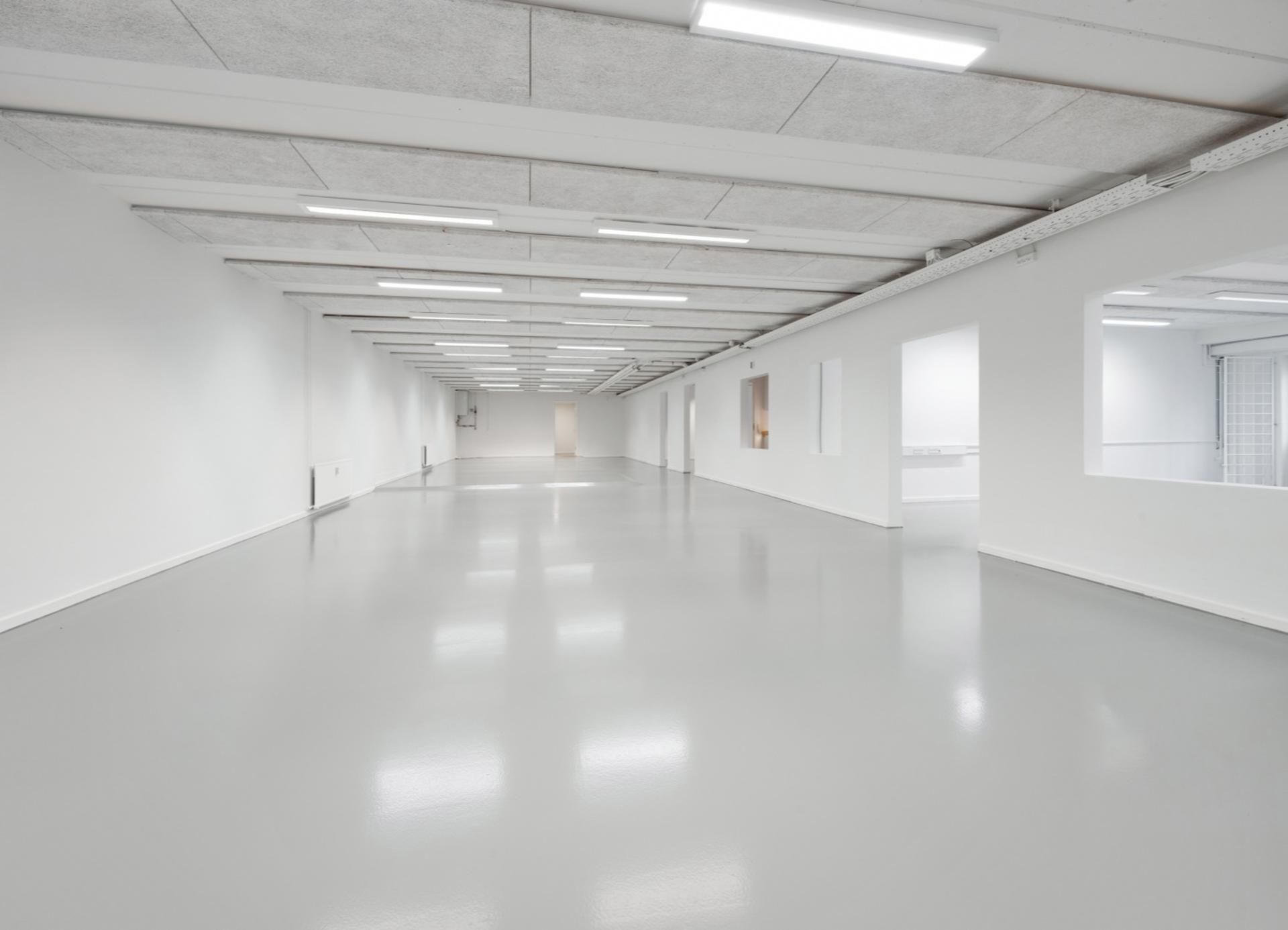 Langt, tomt og hvidt erhvervslejemål med højt til loftet og lyse, funktionelle lofter i Skovlunde