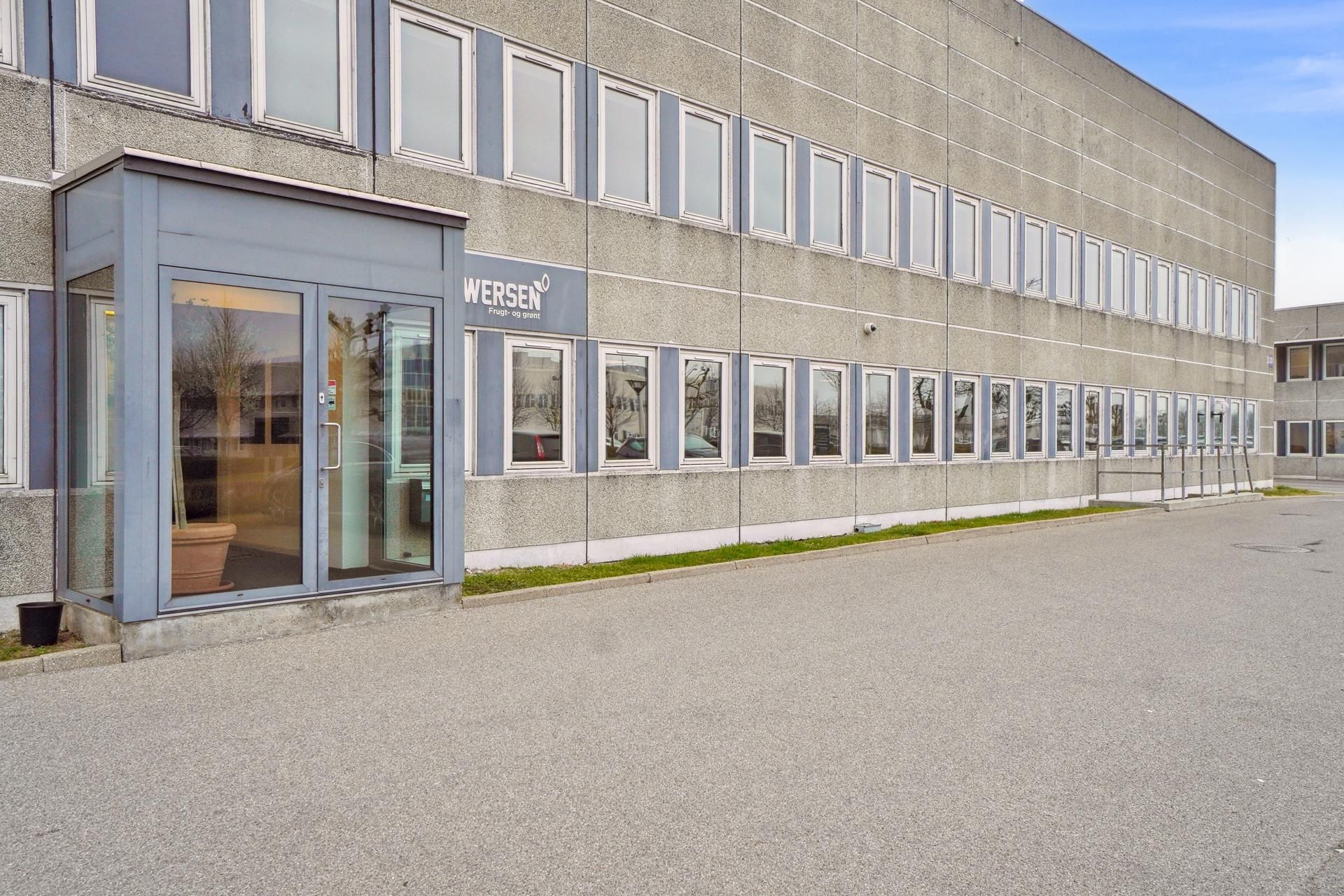 Kontorbygning i Klovtofte med indgangsdør, glasruder og navneplade med teksten Wersen. Lys, velholdt bygning med stribede