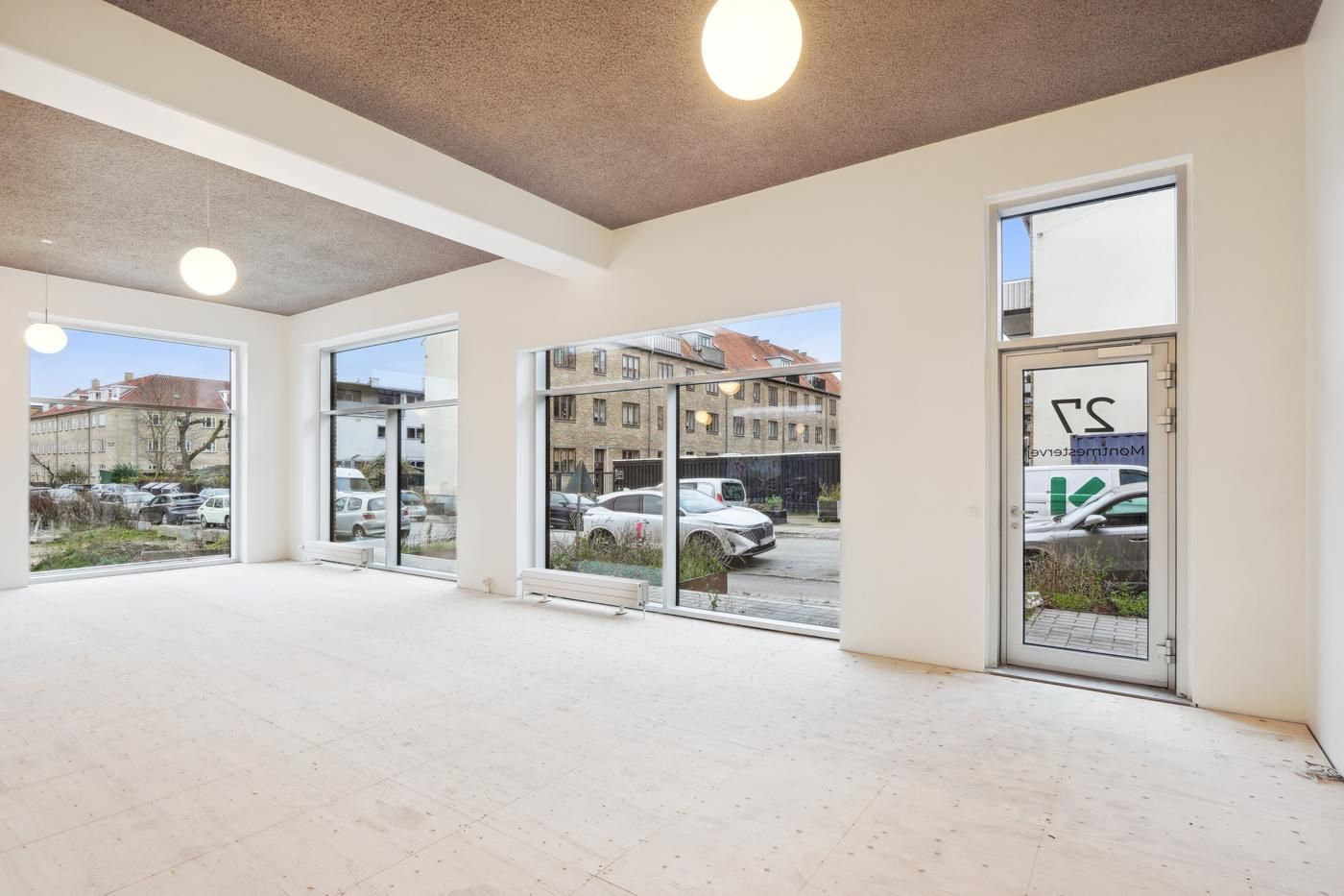 Moderne og lyserødt kontorlokale med glasvinduer og hvide vægge uden møbler og udsmykning