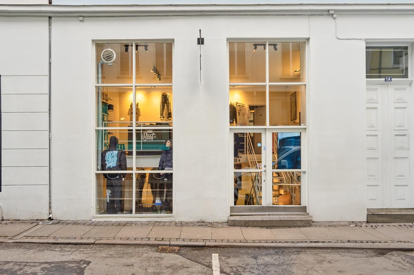 Mennesker står i et butiksvindue og sælger tøj og andre varer til salg