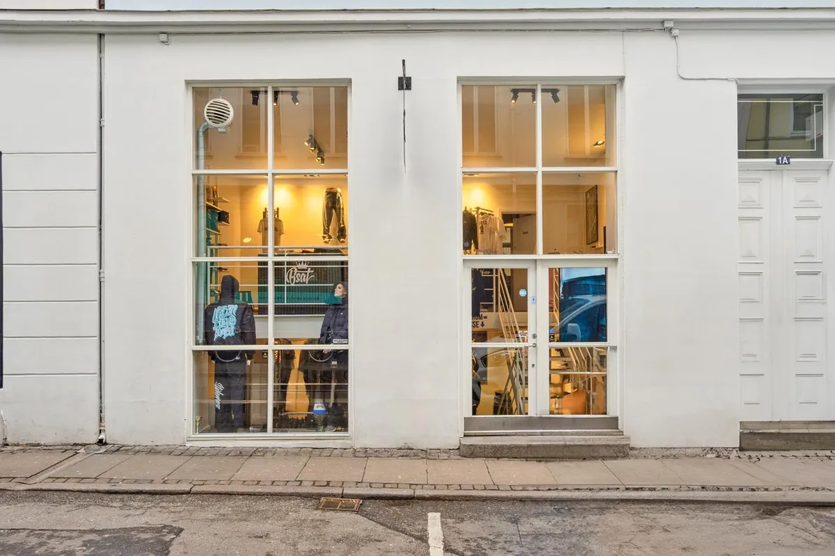 Mennesker står i et butiksvindue og sælger tøj og andre varer til salg