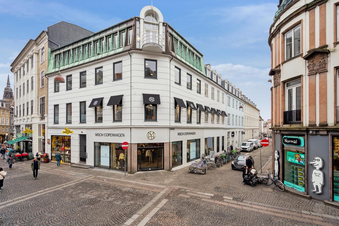 Butik med udsalg af tøj og tøjtilbehør liggende på Knabrostræde. Butikken er hvid med mørke vinduer og har skilte med