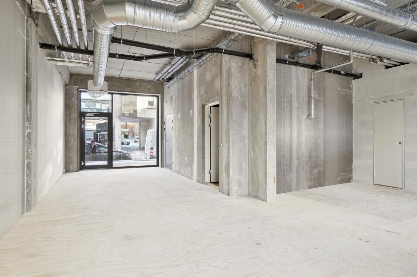 Moderne loft med højt gulv, flere vinduer og eksponerede rør i et hjørnelejemål