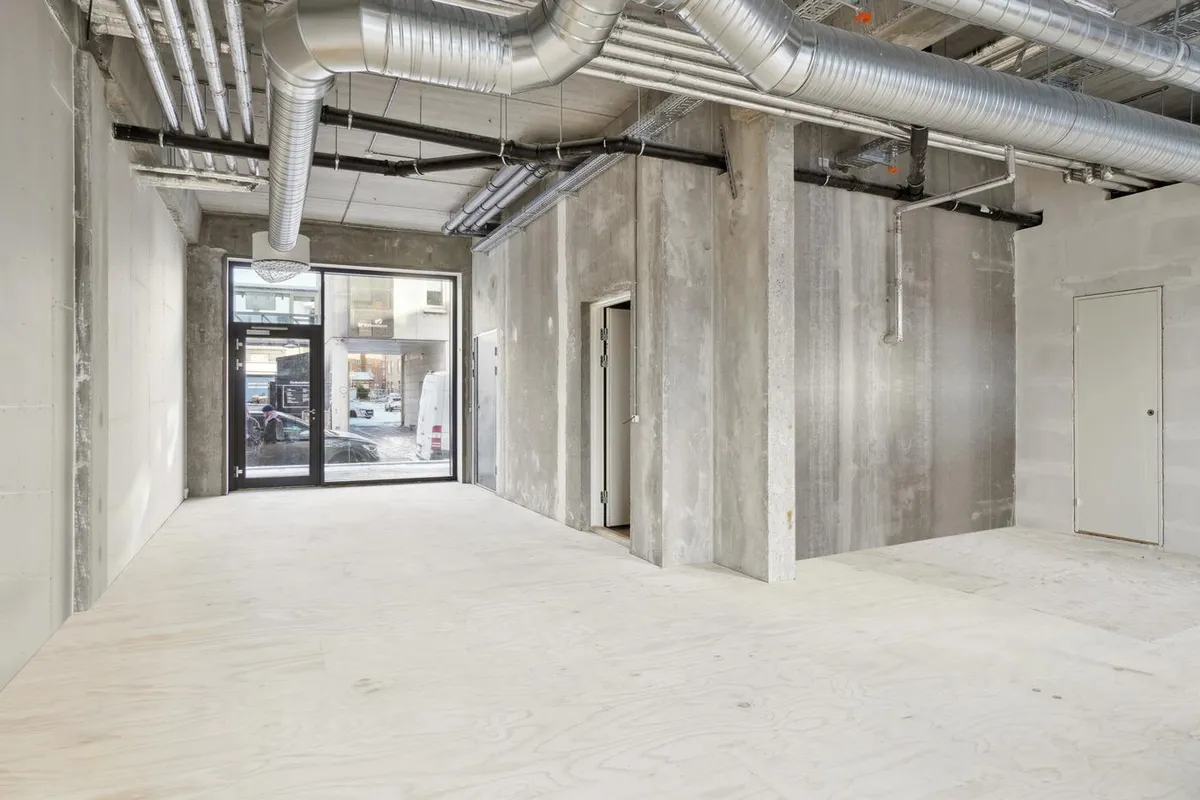 Moderne loft med højt gulv, flere vinduer og eksponerede rør i et hjørnelejemål