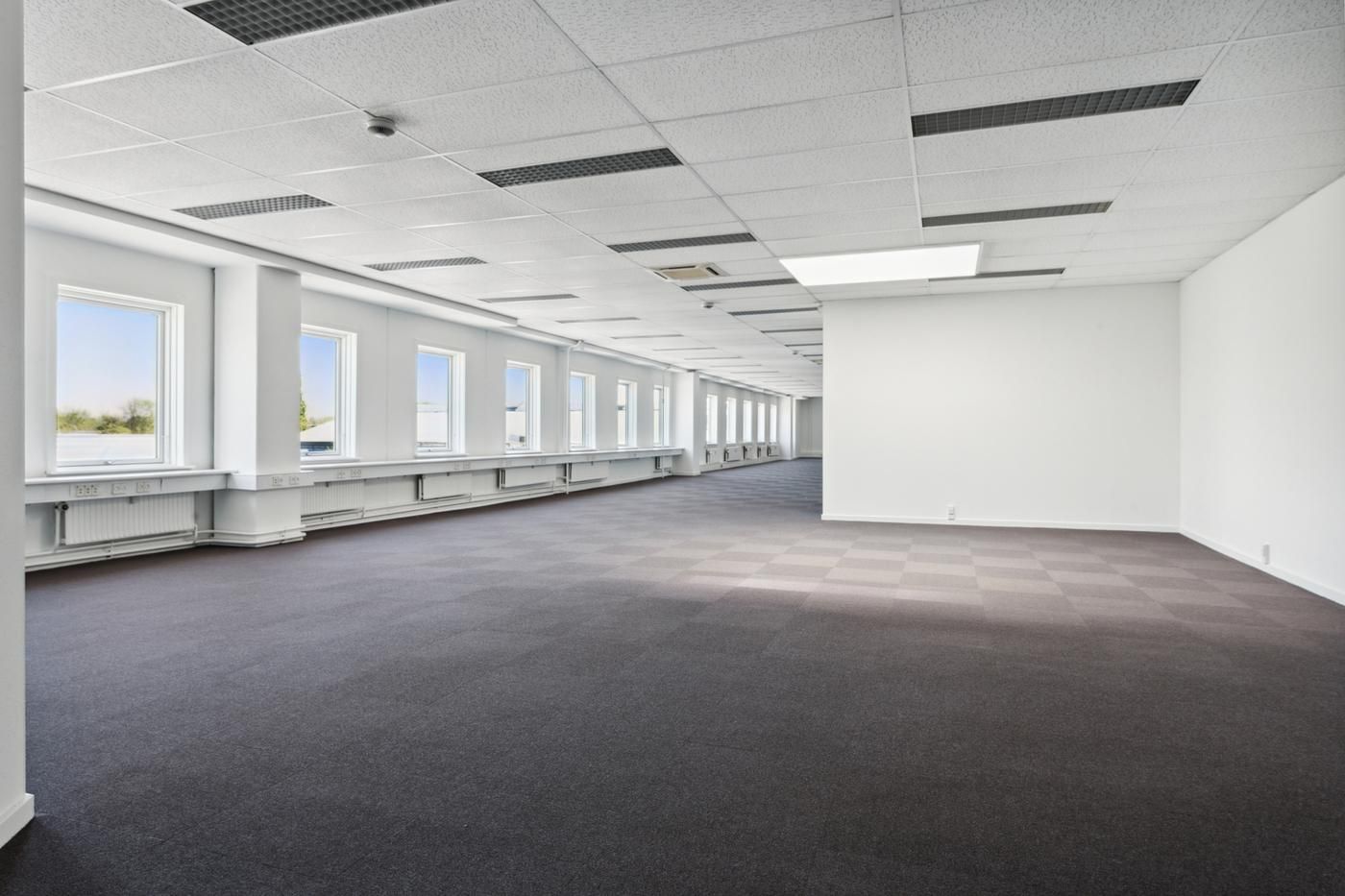 Forretningslejemål i Glostrup med karakteristiskt hvidt loft og gulv, lysevinduer og moderne ventilationssystemer