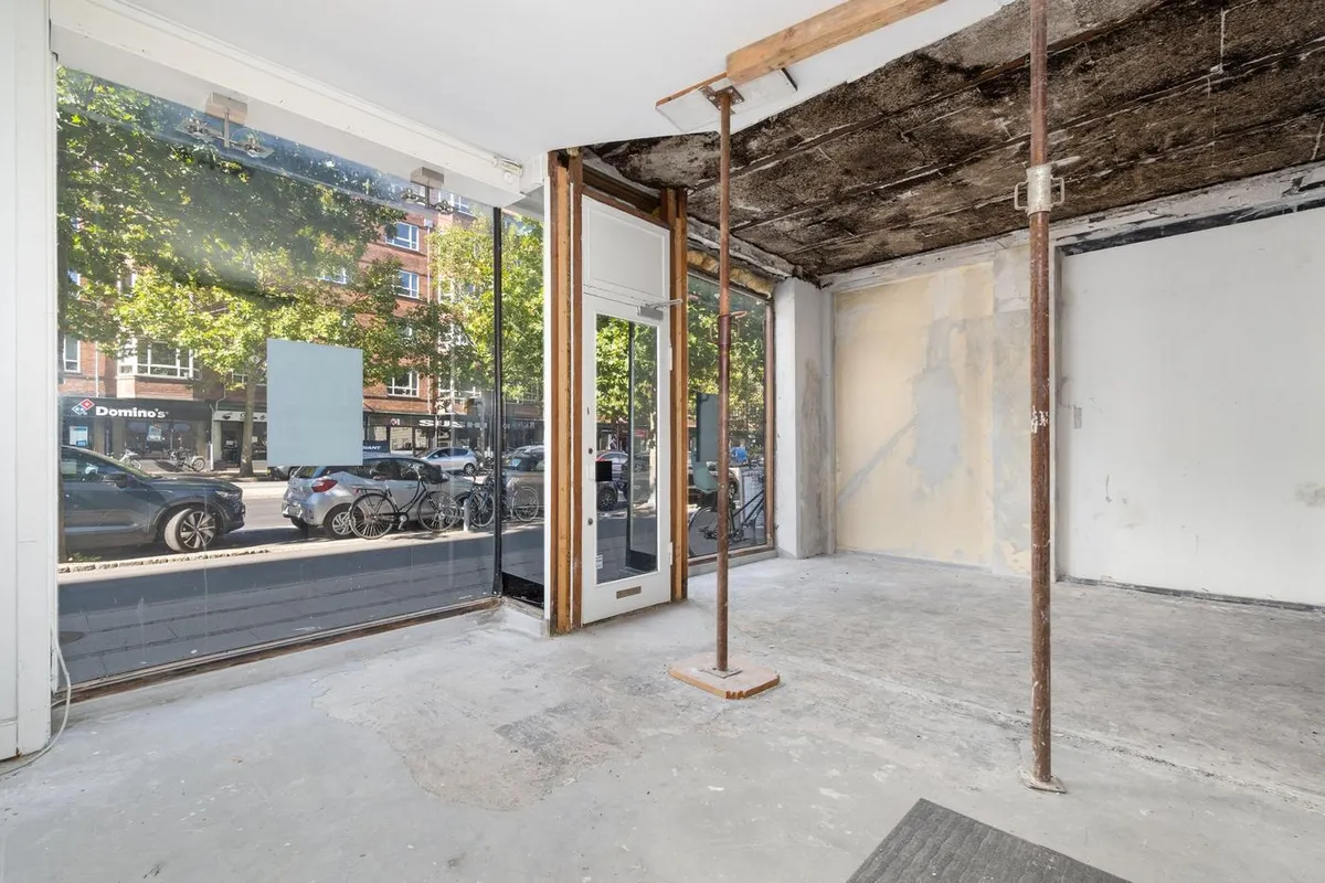 Indenfor en renoveret bygning er der udsigt til Domino's-pizza og biler parkeret langs gaden