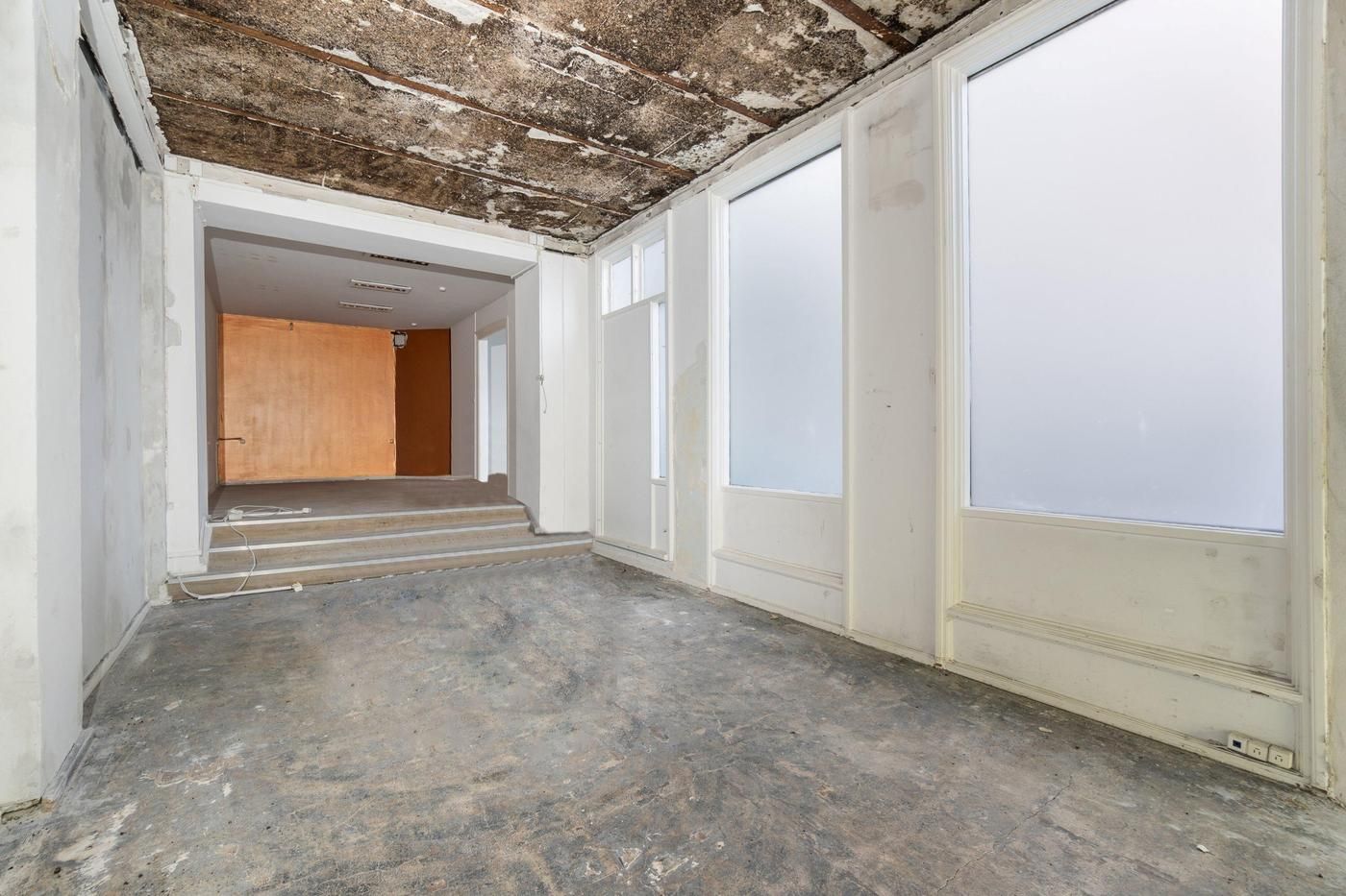 Store tomme rum med højloft og lyse vinduer, trætrapper og hvide vægge samt gulve