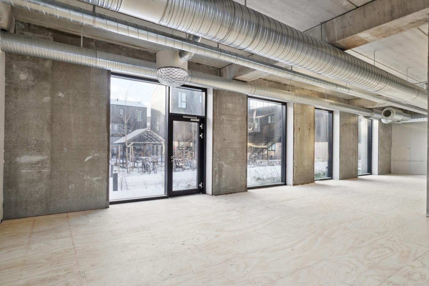 Lejemål med store ruder, højloft og pladegulv til kontorer eller butikker