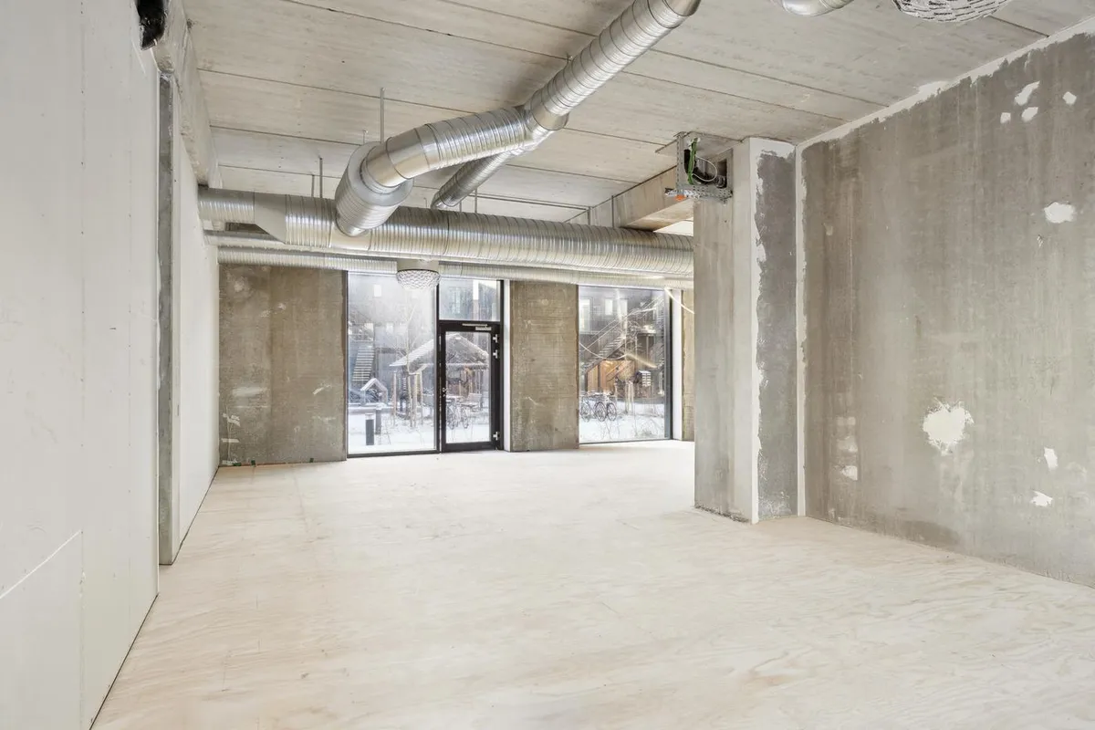 Tomt erhvervslokale med højt til loftet og store vinduer tilstrømmer masser af naturlys ind i rummet