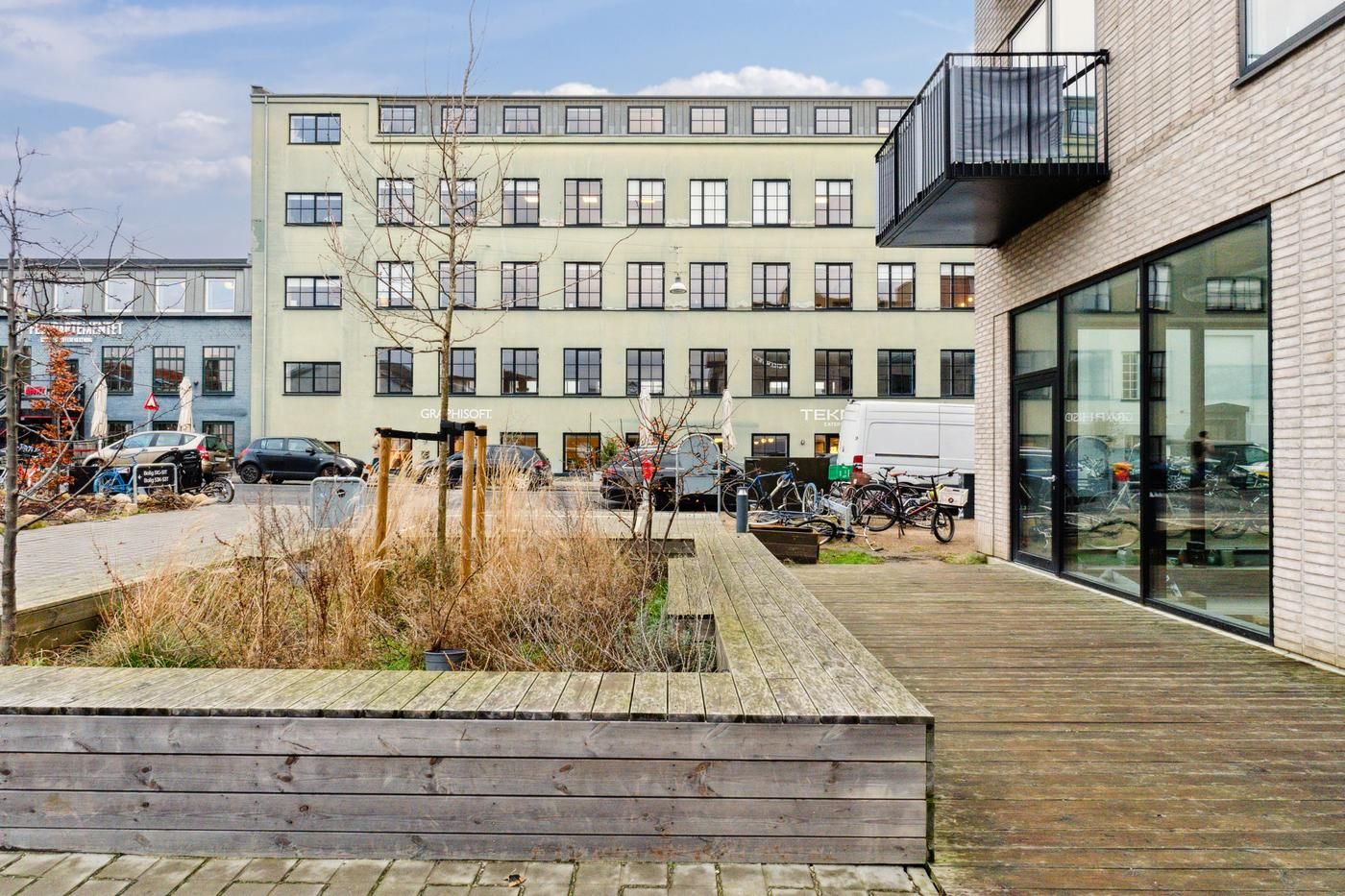 Rummeligt lejemål med terrasse i et moderne kvarter med lyse lofter, glasvinduer og udsigt til park.