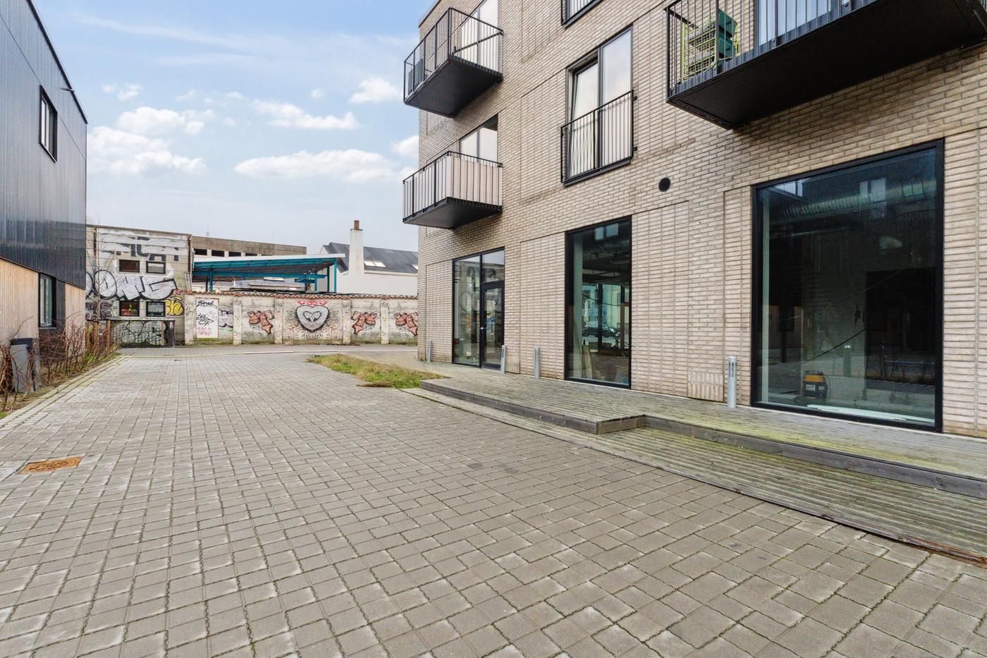 En nybygget, moderne lejlighedsbygning med et stort, grafisk design på facaden og flere balkoner.