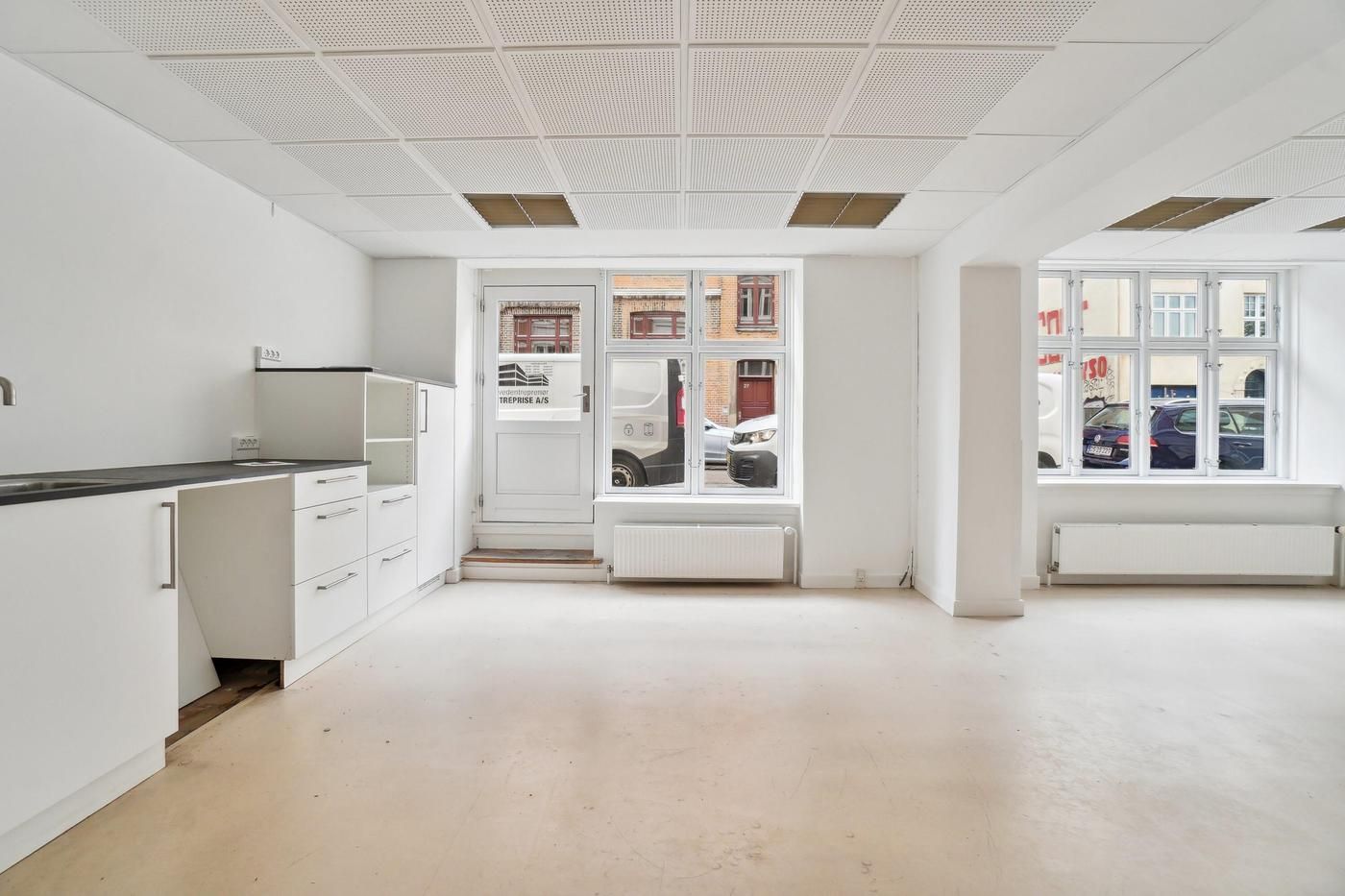 Moderne erhvervslejemål med hvide vægge, gulv og loft samt vinduer og døre