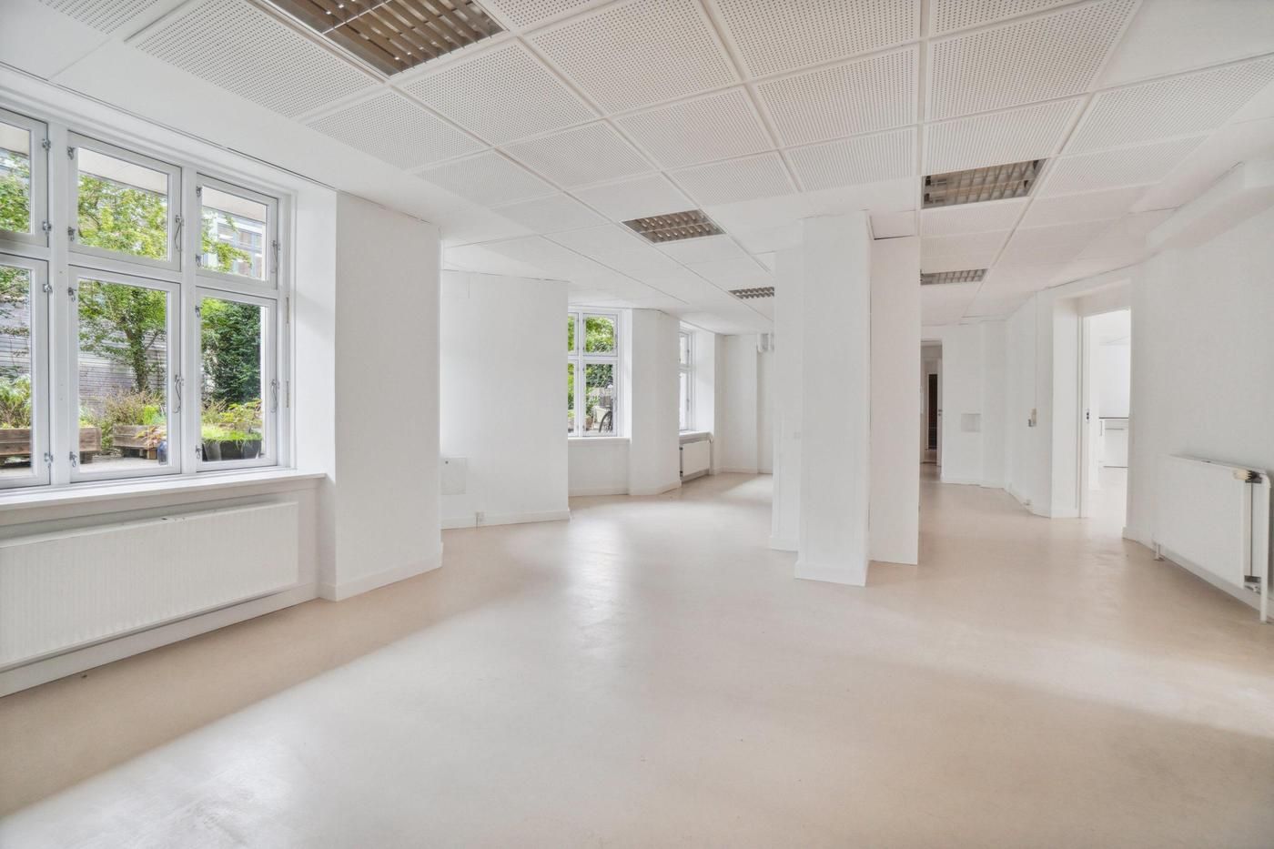 En hvid, tom og ren kontorfællesskab med flere vinduer og hvide vægge