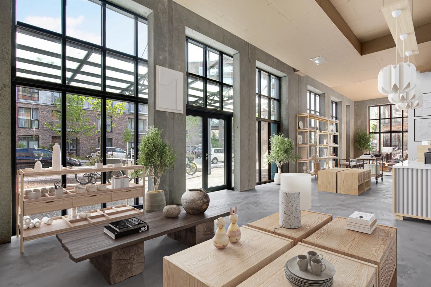 Køkkenborde og blomster, lysekroner og håndværksgenstande, møbler og vinkler i en industriel indretning med store vinduer