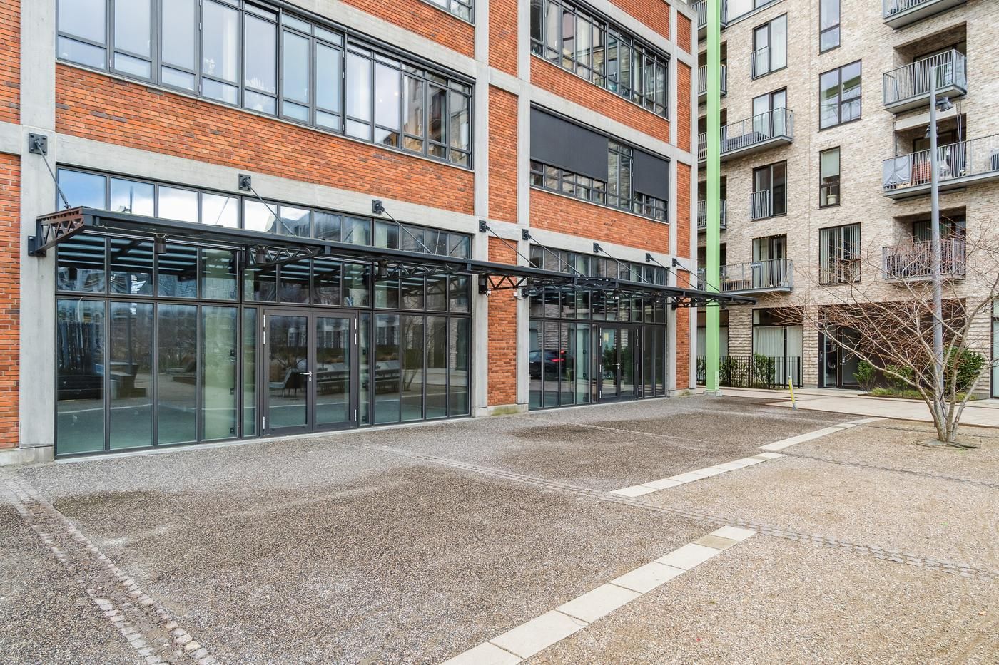 Industrielt bygning med moderne glasfacade og indgangsparti med svære metalstrukturer og glasvinduer