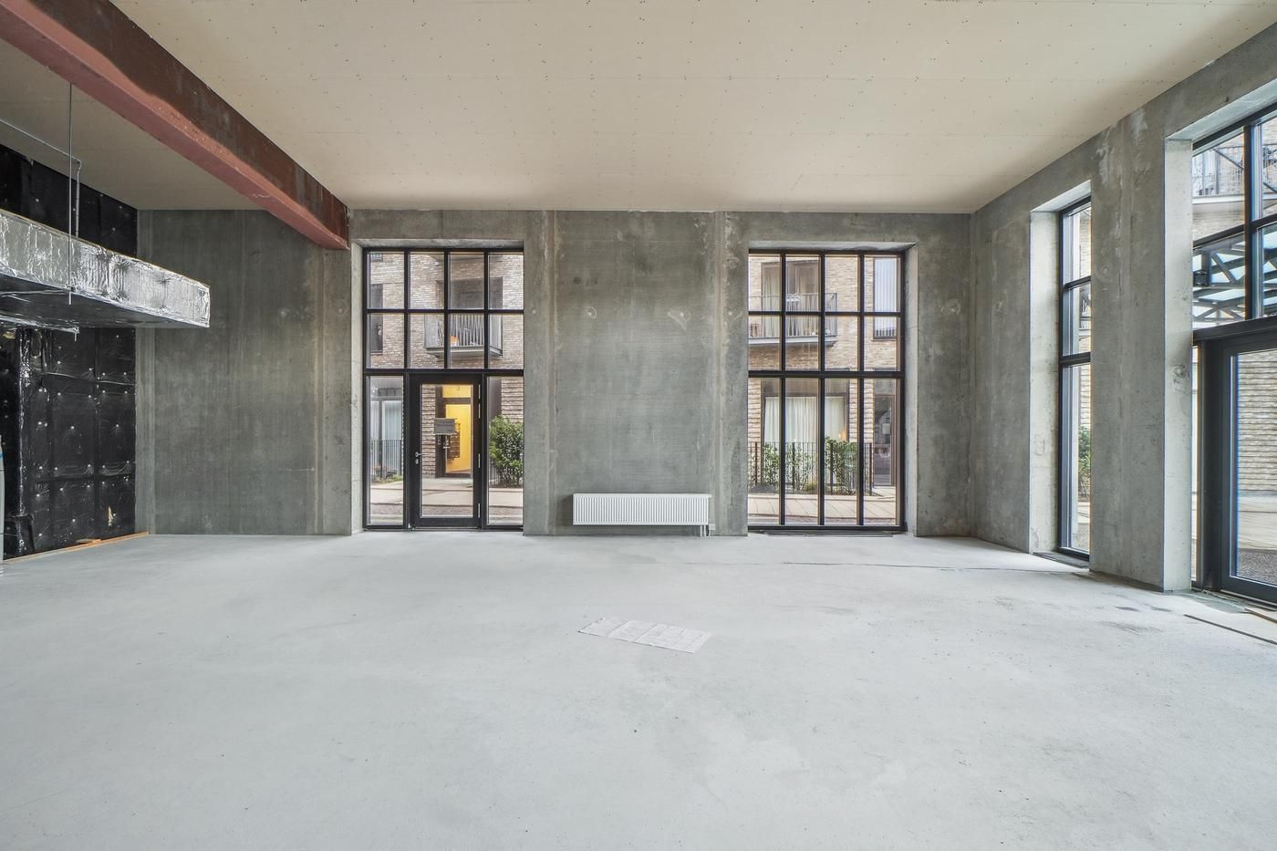Et industrielt lejemål med to store vinduer og to store døre til højre og venstre