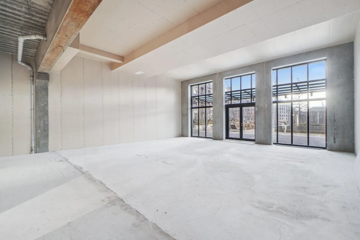 En stor, tom, industriel bygning med højloft og store vinduer samt højt gulv