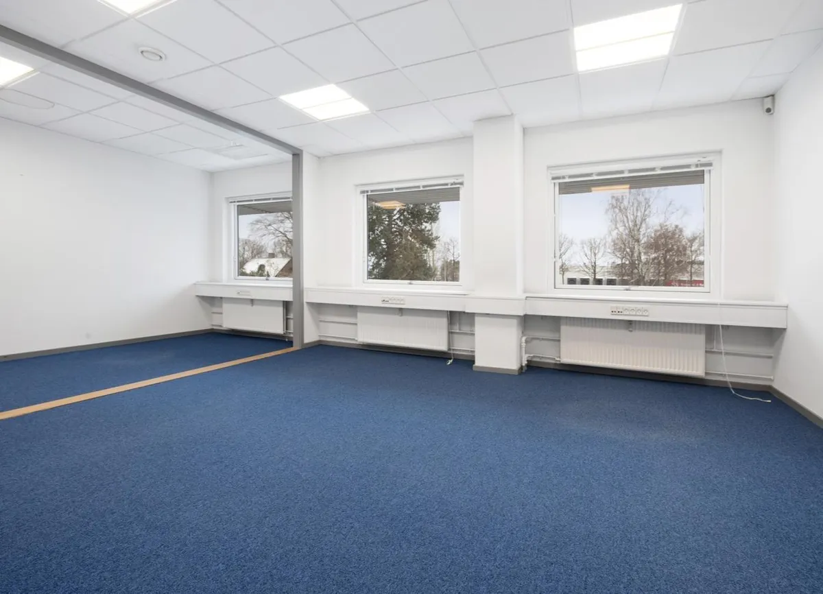 Moderne og lyse kontorlokaler med glasvinduer og radiatorer under hver vindueskarm