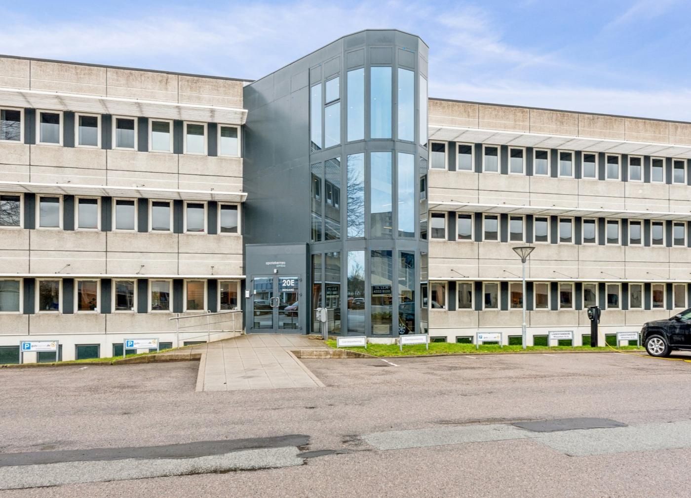En stor kontorvirksomhed med flere vinduer og indgangen til Mileparken 20E 1 i Skovlunde.