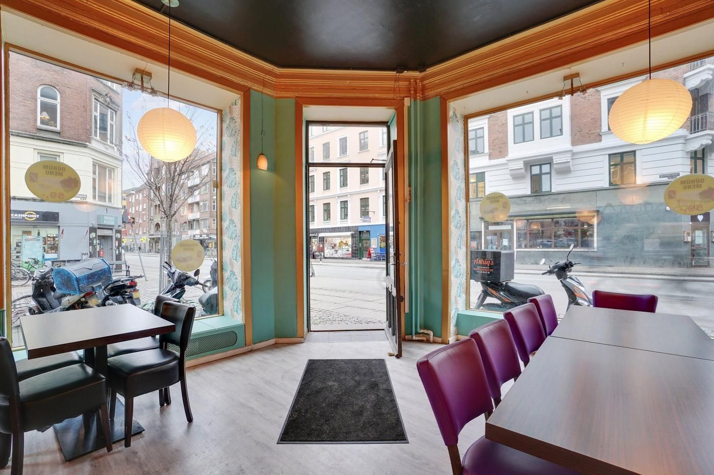 Nørrebro erhvervslokaler med åbent gulv, hjørneborde og møbler, hvor scootere er parkeret udenfor