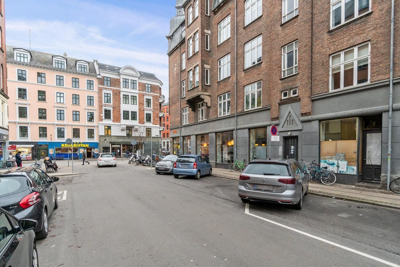 Erhvervsandel med hjørnebeliggenhed på Nørrebrogade med udsigt over gågaden og forretninger med glasvinduer